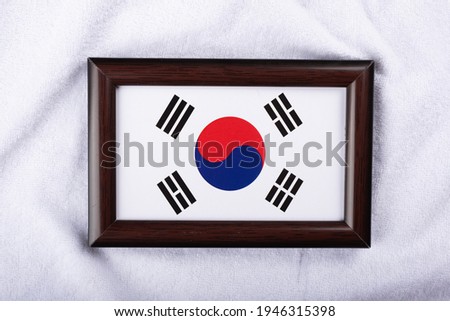 South Korea flag in a realistic frame on white cloth background flat lay photo