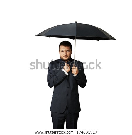 displeased businessman under black umbrella. isolated on white background