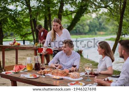 friends having picnic french dinner party outdoor during summer holiday