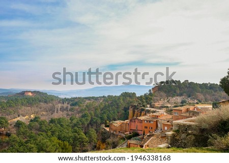 Orange houses on ocher canyon background. Roussillon tourist village. Provence. France.