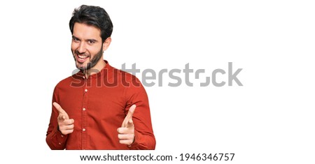 Young hispanic man wearing casual clothes pointing fingers to camera with happy and funny face. good energy and vibes. 