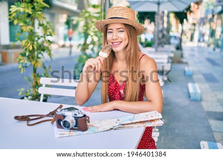 Young caucasian tourist girl smiling happy eating ice cream sitting at coffe shop terrace.