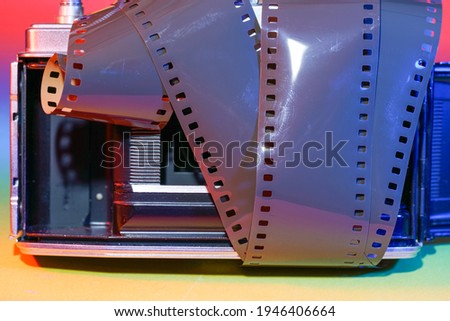 Analogue camera with Film on an colorful background photographed in the studio                             