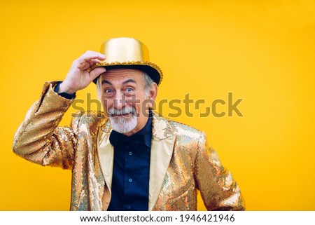 Funny and extravagant senior man posing on colored background - Youthful old man in the sixties having fun and partying Royalty-Free Stock Photo #1946421946