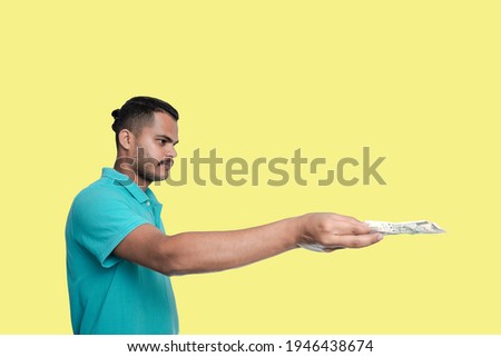 Man holding or giving Old 500 rupee Indian currency note in one hand, on white background 