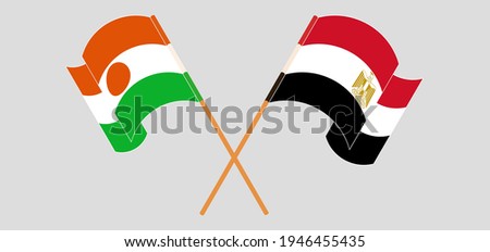 Crossed and waving flags of Niger and Egypt