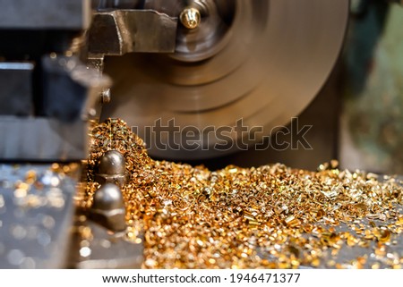 A worker makes a brass and bronze bolt on a lathe.