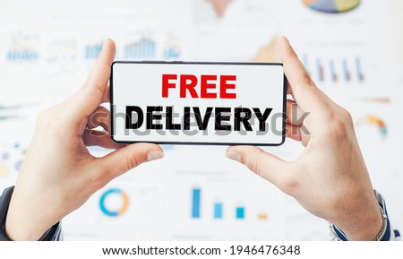 Closeup on businessman holding a smartphone with text Free Delivery. Business concept for directly deliver to the recipient address without charge