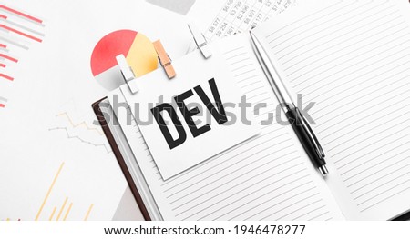 text DEV on stickers on the diary with office tools Royalty-Free Stock Photo #1946478277