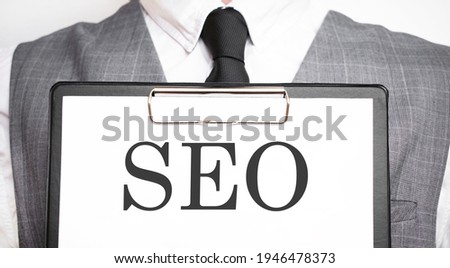 Businessman holding sheet of paper with a message SEO