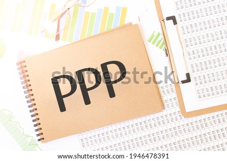 Text PPP LOAN on brown paper notepad on the table with diagram. Business concept