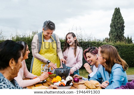 three generations of mexican women grandmother and daughter cooking spicy sauce at home in Mexico city Royalty-Free Stock Photo #1946491303