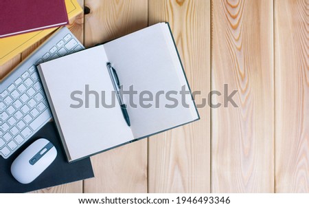 work place with books, keyboard, computer mouse, notebook, open diary and pen on the wood table with copy space