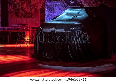 Presentation of a new car. Unknown mysterious car under a black cape.