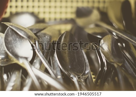 Heap of old aluminum spoons. Is this cookware utensils bad, harmful to cook eat or safe. Cheap price or health compromise. Retro matt tone. Simplicity or poverty concept. Cover design background