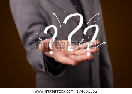 Young business man in suit presenting hand drawn question marks