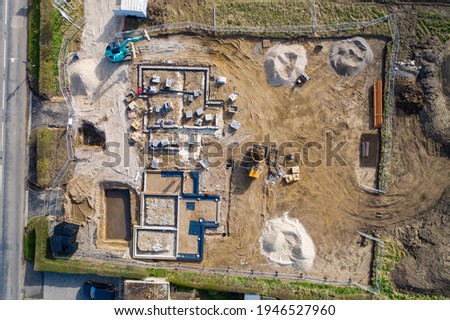 Aerial photo of the UK village of Wetherby in Yorkshire showing building work being done on a property in the village with the foundations of new houses being built in a field