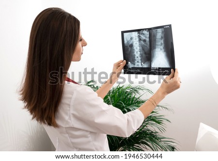 Professional orthopedist examining x-ray picture in medical office. Neurologist is working