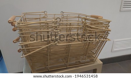 hand-made metal shopping baskets stacked one on top of the other in a store.