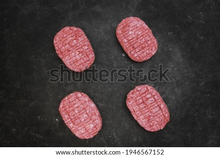 Raw Minced Steak Burgers from Beef and Pork Meat on Black Background, Overhead View. Raw Ground Beef, Round Patties for Cooking Homemade Burger On BBQ Grill, Top View