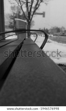 Black and White view of a bus stop bench