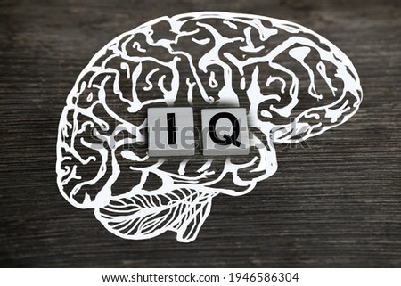 silhouette of the brain, word IQ, intelligence quotient on wooden background, quantitative indicator expressing success, concept of concept of level of mind, intellectual achievements Royalty-Free Stock Photo #1946586304