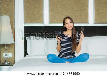 Portrait beautiful young asian woman use smart mobile phone with computer laptop and credit card for online shopping
