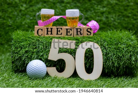 Golf 50th Birthday with golf ball and number fifty with cheers and beers on green grass