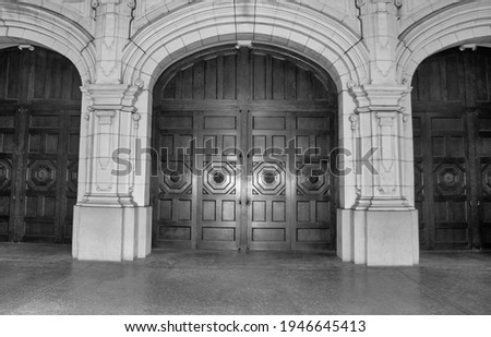 large wooden ornate door in black in white on Balboa park's building in San Diego, CA.