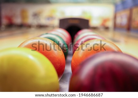 Colorful balls on rack in bowling club closeup