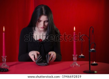 young girl guessing with tarot cards on  red background