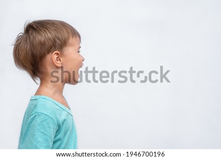 Happy child portrait in profile on gray background