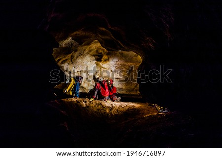 Group of speleologists resting during a cave exploration Royalty-Free Stock Photo #1946716897