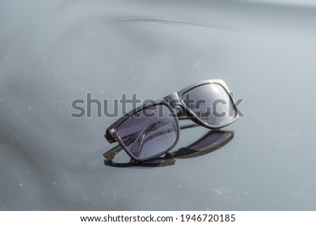 Classic Sunglasses design for men and ladies with black lenses and black frame shoot outside in a summer day closeup. Selective focus