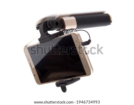 Selfie stick. and pink smartphone. material is black. On white isolated background