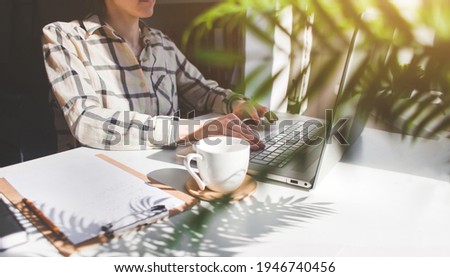 woman in the home office sitting at the table and working on a laptop