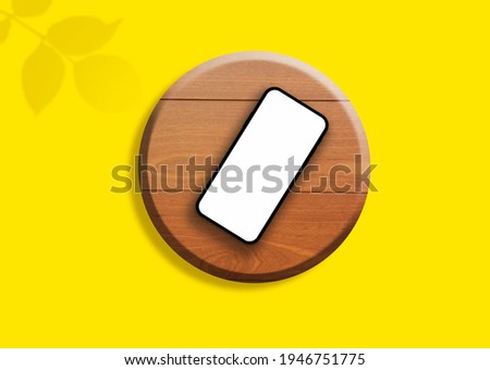 empty phone screen mockup on the wooden table with leaf shadow overlay and yellow background 3d rendering