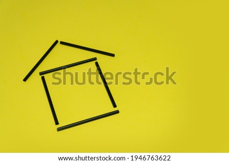 House of black straws on a yellow background