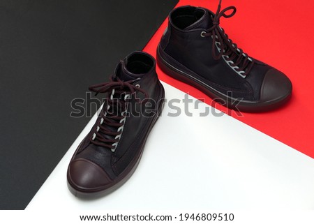 A pair of trendy stylish shoes or sneakers on a colored background with a space for text
