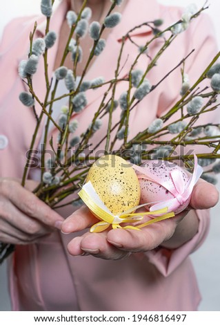 woman in pink jacket
     holds pussy willow and painted eggs for Easter. Happy easter concept cropped photo