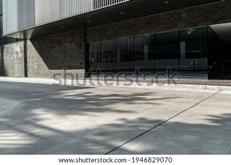 empty concrete road outside of modern office building. selective focus on road. Royalty-Free Stock Photo #1946829070
