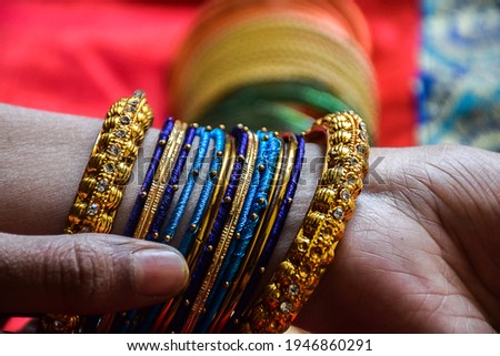 Stock photo of a hand of Indian women wearing colorful bangles with gold Indian design bracelet, picture captured at the time of Indian wedding season at Bangalore Karnataka India.