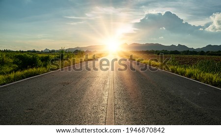 Blurry of road in the middle of asphalt road at sunset.Concept of planning and challenge or career path,business strategy,opportunity and change.New year 2022 or start straight concept. Royalty-Free Stock Photo #1946870842