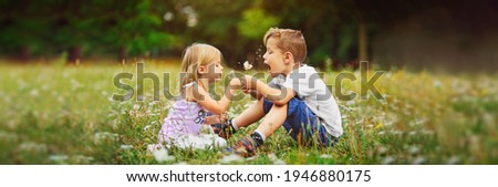 happy children play outdoor with the dandelions