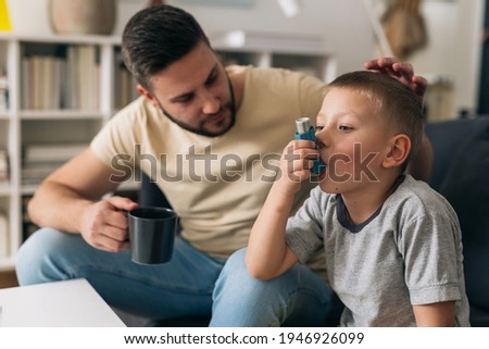 boy using asthma pump at home Royalty-Free Stock Photo #1946926099