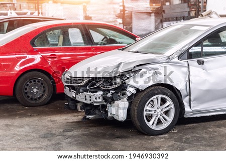 Many wrecked car after traffic accident crash at restore service maintenance station garage indoor. Insurance salvage vehicle auction wholesale storage. Auto body wreck damage work workshop center Royalty-Free Stock Photo #1946930392