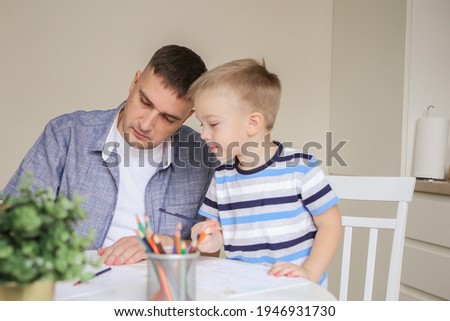 Happy family. Father and son are drawing together. An adult man is engaged with his son. cute kids doing arts and crafts at home