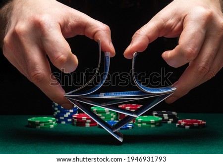 Close-up hands of a person-dealer or croupier shuffling poker cards in a poker club on the background of a table, chips. Poker game or gaming business concept Royalty-Free Stock Photo #1946931793
