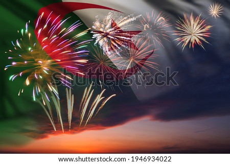 Holiday night sky with fireworks and flag of Algeria for Independence day