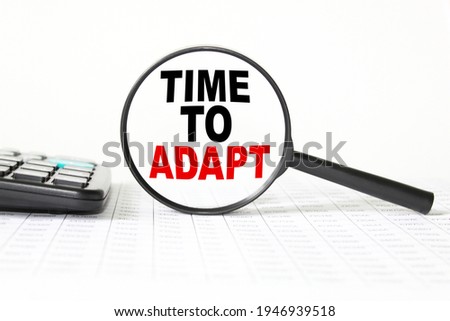 words TIME TO ADAPT IN a magnifying glass on a white background. business concept